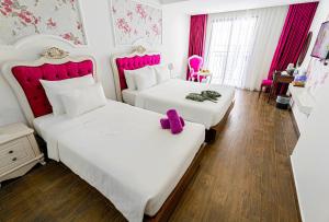 Giường trong phòng chung tại Bonjour Nha Trang Hotel
