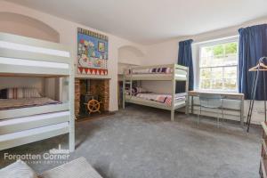 a bedroom with two bunk beds and a window at Woodleigh in Cawsand