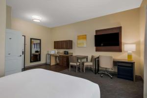 ein Hotelzimmer mit einem Bett, einem Schreibtisch und einem TV in der Unterkunft Comfort Inn & Suites Barnesville - Frackville in Barnesville