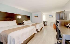 a hotel room with two beds and a desk at Quality Inn & Suites in Lincoln