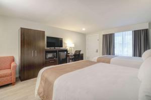 a hotel room with two beds and a television at Quality Inn & Suites in Lincoln