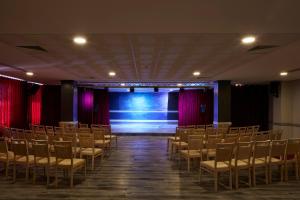 una habitación vacía con sillas y un escenario en Albufeira Sol Hotel & Spa en Albufeira