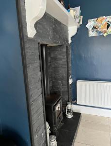 a brick fireplace in a room with a stove at Ebenezer in Carnlough