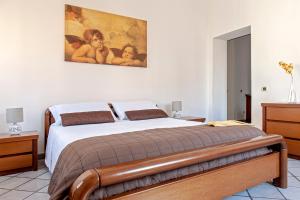 a bedroom with a bed with a painting on the wall at La casa di Chiara in Livorno