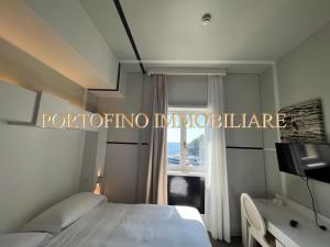 een slaapkamer met een bed en een raam bij PORTOFINO SUITE VISTA MARE CON SPIAGGIA PRIVATA in Portofino