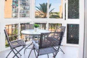 a table and chairs in a room with windows at Las Estrellas 301 in Torremolinos