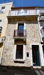 a building with a balcony and a window at Maison de village rénovée ! in Le Grau-du-Roi