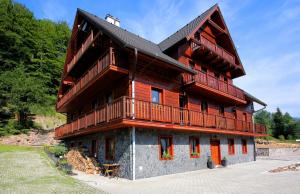 a large wooden house with a gambrel at Bystrá Apartment in Bystrá
