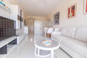 a living room with a white couch and a table at Luxury studio in beachfront complex in El Duque area, Costa Adeje in Adeje