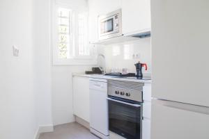 a white kitchen with a stove and white cabinets at Las Estrellas 301 in Torremolinos