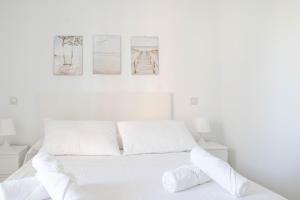 a white bedroom with a white bed with three pictures on the wall at Las Estrellas 301 in Torremolinos +25 photos