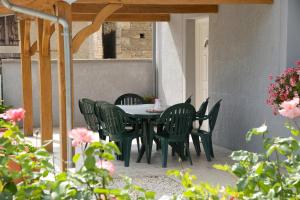 ein Tisch und Stühle auf einer Terrasse mit Blumen in der Unterkunft Le saint laurent in Morvilliers + 10 Fotos
