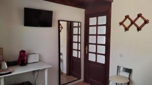 Mi habitación de invitados في بويرتو ديل روزاريو: غرفة بها مرآة وتلفزيون على الحائط