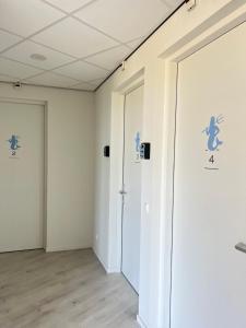 una stanza vuota con pareti bianche e due porte di Neptunus Appartementen a Bergen aan Zee