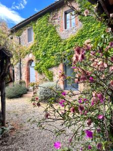 een bakstenen huis met roze bloemen ervoor bij La Palazzina in Siena