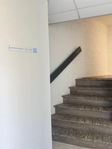 una escalera en un edificio con un cartel en la pared en Neptunus Appartementen en Bergen aan Zee