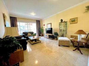a living room with a couch and a table at Beautiful apartment with pools, playground and paddle tennis - Family friendly and near Vithas Hospital - Free parking in garage in Benalmádena