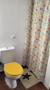 e bagno con servizi igienici gialli e tenda per la doccia. di Mi habitación de invitados a Puerto del Rosario