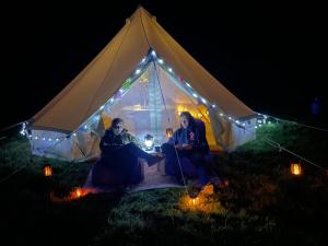 a group of people sitting in a tent at night at West Holme Glamping in Wareham