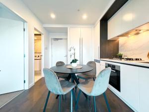 een keuken met een tafel en stoelen in een kamer bij Apartment with nice view in Boxhill 8A in Box Hill
