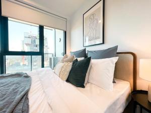 een slaapkamer met een bed met kussens en een raam bij Apartment with nice view in Boxhill 8A in Box Hill