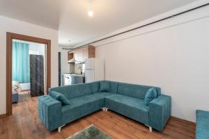 uma sala de estar com um sofá verde e uma cozinha em Zeus Suit Görükle em Nilüfer