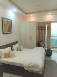 Un dormitorio con una gran cama blanca con almohadas. en Best Cozy Stay in Central Noida , Mall, Free WiFi, Parking, Private Apartment - The Taj Studios, en Noida 34 fotos más