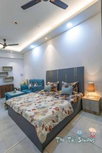 Un dormitorio con una cama grande y un sofá. en Best Cozy Stay in Central Noida , Mall, Free WiFi, Parking, Private Apartment - The Taj Studios, en Noida