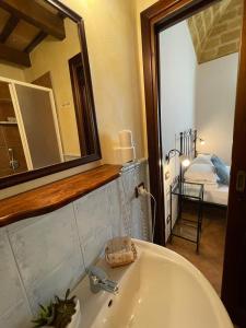 サン・ヴィート・ロ・カーポにあるAi Dammusi Roomsのバスルーム(シンク、鏡、ベッド付)