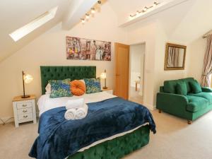 a bedroom with a large bed and a green chair at Bradley Manor in Huddersfield