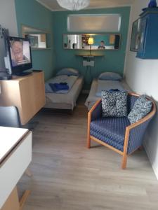 a room with two beds and a couch and a tv at Centrum Aarhus in Aarhus