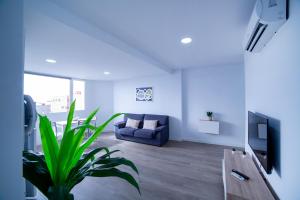 een woonkamer met een blauwe bank en een tv bij Avenida 40 in Vecindario