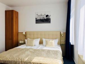 a bedroom with a large bed with white sheets and pillows at Hotel am Bayrischen Platz in Leipzig