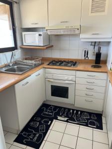 a kitchen with a stove top oven next to a sink at Agradable Dp San Alfonso del Mar in Algarrobo +9 photos