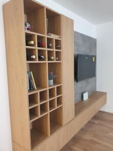 a wooden book shelf with a tv in a room at Sarajevo Charm Apartment in Sarajevo
