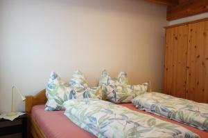 - une chambre avec 2 lits et des oreillers dans l'établissement Ferienwohnung Mader, à Kolsass