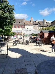 un groupe de tables et de chaises sur une rue de la ville dans l'établissement Appartement immeuble le bringer 180m2, à Marvejols