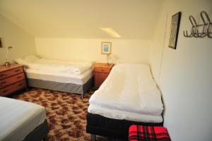 a small bedroom with two beds and a dresser at Fredelig med naturskjønn omgivelse, midt i Lofoten in Jerstad