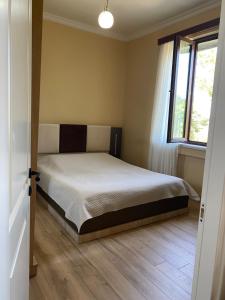a bedroom with a bed and a window at Zurkas’ guesthouse in Batumi