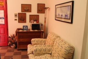 a living room with a chair and a desk at B&B I Mari in Torpè