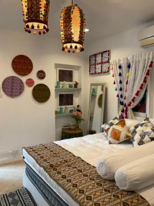 a bedroom with a large bed and two chandeliers at Pangsuree Art Home in Lampang