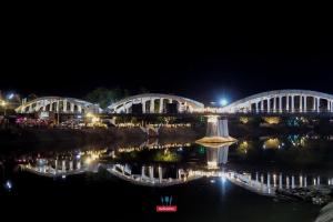 a bridge over the water at night at Pangsuree Art Home in Lampang