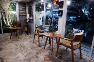 a room with chairs and a table and some windows at Pangsuree Art Home in Lampang