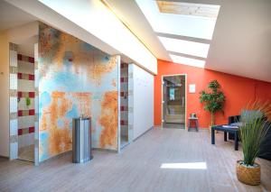 an office lobby with orange walls and a mural at JUFA Hotel Altenmarkt-Zauchensee in Altenmarkt im Pongau