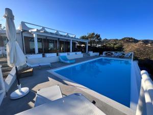 a swimming pool with chairs and a house at Villa Elicis in Pinus Village
