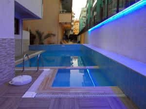a swimming pool in a building with blue lights at Aysev Hotel in Alanya