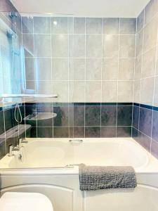 a bathroom with a white tub and a toilet at Modern 3 bed home, Chesterfield in Chesterfield