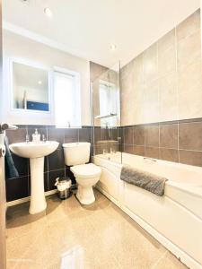 ein Badezimmer mit einem Waschbecken, einem WC und einer Badewanne in der Unterkunft Modern 3 bed home, Chesterfield in Chesterfield