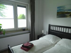 a bedroom with a bed and a window at Ferienhof Ostarle in Arle