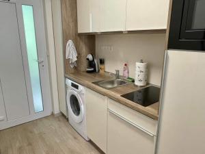 a kitchen with a sink and a washing machine at Bella Luna in Balatonfüred